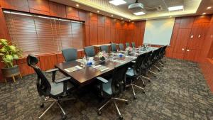 Al ‘AqrabīyahTamimi Geshla Residency的一间会议室,配有长桌子和椅子