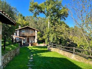 ArgomillaEl currillo preciosa casa rural al lado cabarceno的一座带栅栏和草地的古老石屋