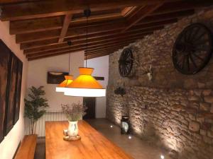 ArgomillaEl currillo preciosa casa rural al lado cabarceno的一间设有台灯和石墙的桌子的房间