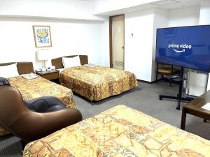 札幌Hotel Tokeidai的客房设有三张床和一台平面电视。