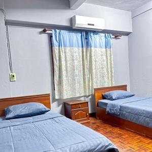 Ban NongdouangSaysouly Guest House的小房间设有两张床和窗户