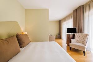奥利维拉多霍斯比托Alva Valley Hotel的配有一张床和一把椅子的酒店客房