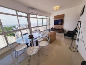 萨尔瓦多Luxury Surround Sea View Apartment的客厅配有玻璃桌和椅子