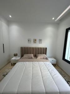 突尼斯joli appartement a jardin de Carthage的白色卧室内的一张大白色床