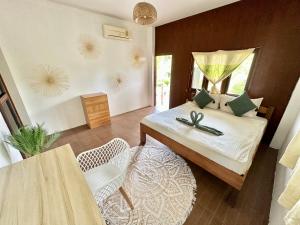 帕干岛Oh'lala Bungalow的卧室配有一张床和一张桌子及椅子
