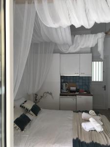 金尼昂Morpheus Rooms的一间卧室配有白色窗帘的床