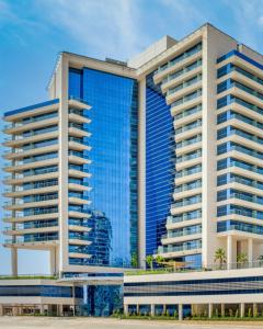 迪拜The First Collection Business Bay的带有蓝色窗户的建筑的 ⁇ 染