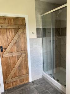 雷特福德Woodside Retreat with Luxury Hot Tub的带淋浴的浴室和滑动木门。