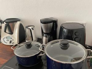 开姆尼茨Ferienwohnung von der Herzogshöhe ,WIFI, Netflix, Parkplatz, Kamin, Fussbodenheizung, Thermomix, Babybett的一个带两个壶和咖啡壶的柜台