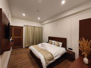 列城Zanu Residency的一间卧室配有一张大床和电视
