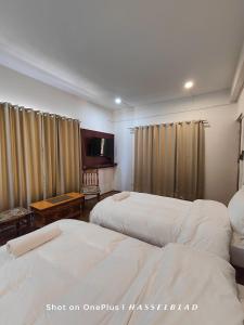 列城Zanu Residency的酒店客房设有两张床和电视。