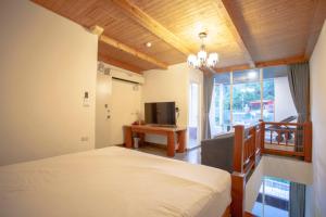 南湾蝴蝶旅店的一间卧室设有一张床、一台电视和一个窗口。