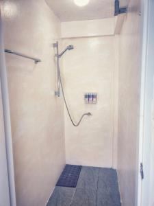 曼谷HOLY SHEET Hostel的带淋浴的浴室(铺有瓷砖地板)