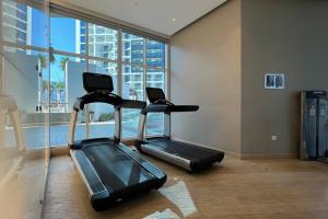 迪拜Business Bay centrally located Cozy Studio的健身房设有跑步机和大窗户