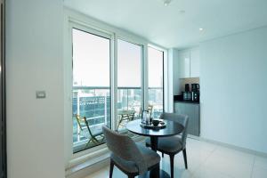 迪拜Business Bay centrally located Cozy Studio的一间带桌椅和窗户的用餐室
