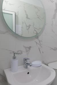 卡萨米尔Vila Kristian的白色的浴室设有水槽和镜子