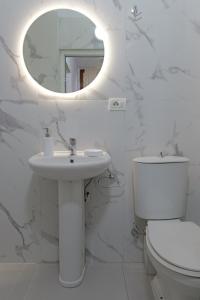 卡萨米尔Vila Kristian的白色的浴室设有水槽和镜子
