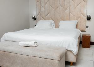 布兰太尔Sunnyside Inn的卧室配有白色大床和长凳