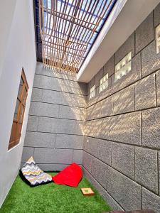 TimuranOmah Tabon Jogja - Dekat Dengan Malioboro的砖墙旁边的地板上有一个红色的袋子的房间