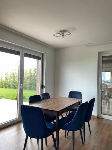 乌罗舍瓦茨Villa Ozoni 2 - Jezerc的一间带木桌和蓝色椅子的用餐室