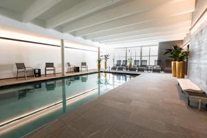 因斯布鲁克伊格尔斯运动酒店的一座带桌椅的游泳池