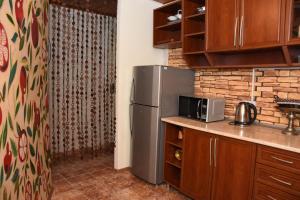 第比利斯Relax Inn Tbilisi的厨房配有不锈钢冰箱和砖墙