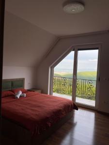 乌罗舍瓦茨Villa Ozoni 2 - Jezerc的一间卧室设有红色的床和大窗户