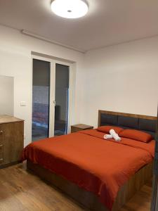 乌罗舍瓦茨Villa Ozoni 2 - Jezerc的一间卧室配有一张大床和红色的床罩