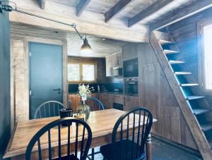 夏蒙尼-勃朗峰Le Chalet Georges的厨房配有木桌和椅子,设有楼梯