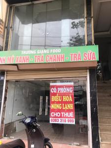 Dien Bien PhuA Thía Hostel的停在商店窗口前的摩托车,有标志