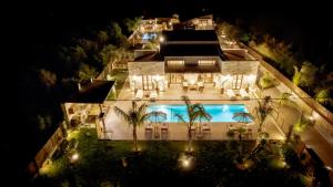 利萨基亚White Stone Luxury Villa的享有大楼空中景色,晚上设有游泳池