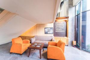 Klandasan KecilAdika Hotel Bahtera的客厅配有橙色椅子和沙发