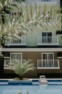 PusokAmani Grand #332, Near Mactan Airport,Fast WIFI, Netflix & Pool的一座建筑的模型,前面有棕榈树