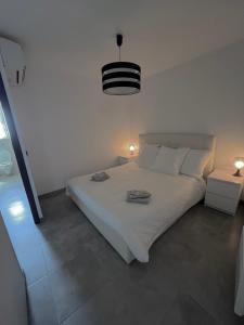 博尔马斯·莱斯·米默萨斯Villa LEOVI Superbe logement 3 pieces - 7 personnes, à 100m plage la Faviere的卧室配有白色的床和2条毛巾