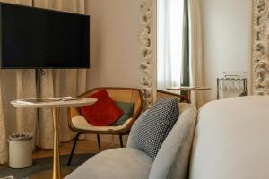 罗马Sofitel Roma Villa Borghese的卧室配有1张床、1张桌子和1把椅子