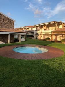 帕劳LOTUS Wellness Apartment - Resort Ginestre - Palau - Sardinia的庭院中间带游泳池的大房子