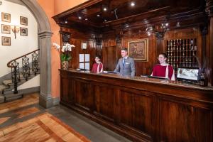 佛罗伦萨佛罗伦萨海尔维迪亚&布里斯托尔酒店 - 星际酒店集团的一名男子和两名妇女站在酒吧后面