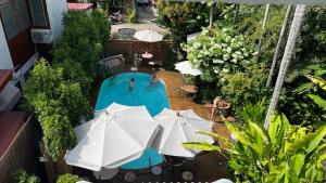 清迈20小屋客栈- SHA Extra Plus的享有带遮阳伞的游泳池的顶部景致