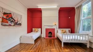阿什顿下安林恩Sleeps 20 Stunning Ashton Mansion的红色的客房设有两张床和壁炉
