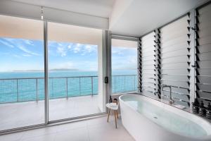耐莉湾美爵公寓磁岛酒店的带浴缸的浴室,享有海景。