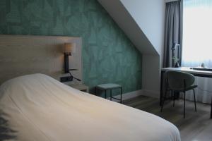 哈默伦哈姆伦瓦品酒店的一间卧室设有一张床和绿色的墙壁