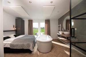 莱森Panorama lodge with wellness and hottub 2 p.的一间卧室设有一张大床和一个浴缸