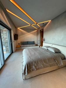 埃尔莫波利斯Syros Soul Private Pool Suites的一间卧室设有一张大床和一个大窗户