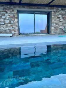 埃尔莫波利斯Syros Soul Private Pool Suites的一座带窗户的建筑前的游泳池