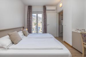 莱维科特尔梅Garden House - Hotel Sport的一间带两张床的卧室和一个阳台