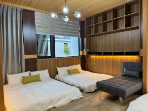 台南Triple One Entire Home 慶東111私人招待所 包棟民宿的一间卧室设有两张床、一把椅子和一个窗户。