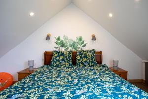 CléguérecOasis tropicale a Cleguerec的一间卧室配有一张带蓝色棉被的床
