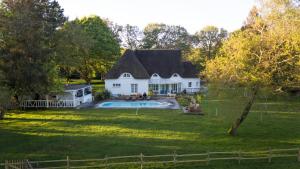 圣利法尔Romantique petite chaumière près de Guérande的一座大型白色房子,在庭院里设有一个游泳池