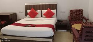 钦奈Mount Heera Hotel-Alandur的酒店客房配有一张带红色枕头的大床