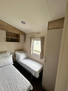 滨海克拉克顿6 Berth Caravan Holiday St Osyth Clacton-on-sea by Verb Holidays的小房间设有两张床和窗户